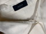 someone is holding a white shirt with a black label on it