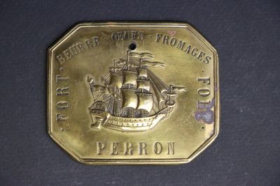 brass plate with a picture of a ship on it on a black surface