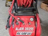 a red air compressor with a hose attached to it
