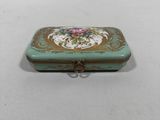 an image of a small green box with a pink flower on it
