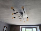 a chandelier in the middle of a room with a window in the background
