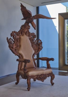 une image représentant une chaise dans une pièce, sur laquelle est posé un oiseau