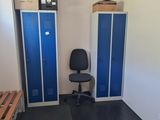 a room with two lockers and a chair in it