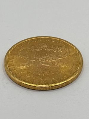 l'image d'une pièce d'or posée sur une surface blanche