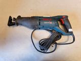 a close up of a corded drill on a table with a cord