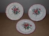 trois assiettes ornées de fleurs posées sur une table