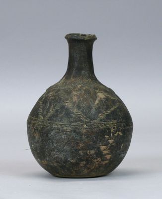 un vase vert posé sur une surface blanche