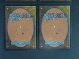two decks of magic the gathering deck are shown on a black surface