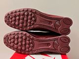 the soles of a pair of red shoes on top of a red and white box