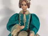 a figurine of a woman wearing a green dress and hat