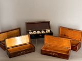 four wooden boxes with silver and wood handles on a white surface