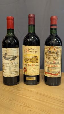 three bottles of wine are lined up on a wooden table