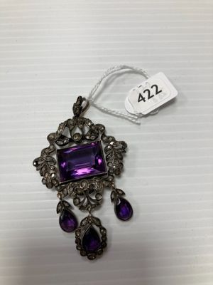 un gros plan d'un collier orné d'une pierre violette