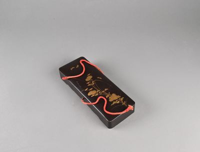 une petite boîte noire à laquelle est attaché un cordon rouge