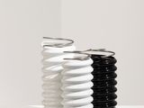 deux vases noirs et blancs posés sur une étagère blanche