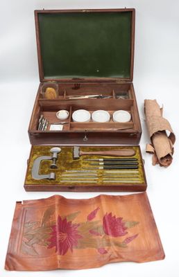 a small wooden box with a leather case and tools in it