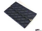 une image représentant une pochette noire et bleue posée sur une surface blanche