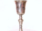 une coupe en argent posée sur une table, sur fond blanc