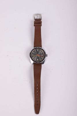 une image d'une montre sur une surface blanche avec un bracelet marron
