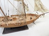 a wooden model of a sail boat on a stand