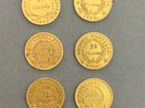 four different types of gold coins on a gray surface