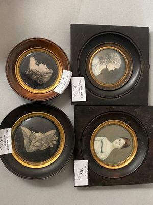 four framed pictures of people in different styles and sizes on a table