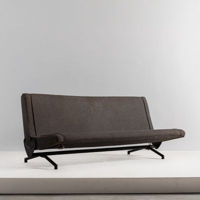 une image représentant un canapé marron posé sur une surface blanche