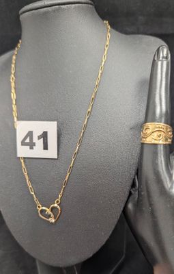 Collier à chaîne en or et bague présentés sur un mannequin, avec étiquette de prix