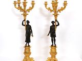 paire de figurines anciennes en bronze représentant un homme et une femme tenant un candélabre