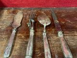 cinq cuillères et un couteau posés sur une table en bois