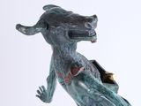 statue of a dragon with a box on its back on a white surface
