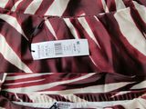 several tags are attached to a dress on a bed