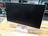 a computer monitor sitting on top of a wooden table