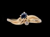une image représentant une bague en or sertie d'un saphir et d'un diamant