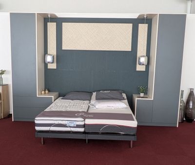 un lit avec une tête de lit intégrée dans une chambre