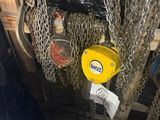 des chaînes suspendues au plafond d'un immeuble à l'aide d'un crochet jaune