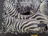 zebras and giraffes are laying on a black and white blanket