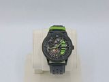 a black and green watch sitting on a display stand