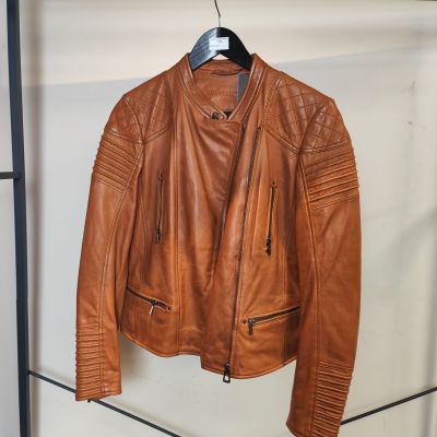 une veste en cuir marron suspendue à un porte-manteau dans une pièce