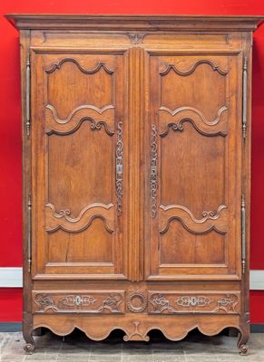 an old wooden armoire against a red wall in a room