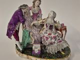 une figurine représentant un homme et une femme assis sur un banc
