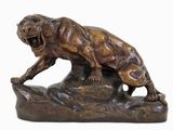 statue en bronze représentant un tigre sur un rocher, la gueule ouverte