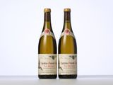 two bottles of wine sitting on top of a table next to each other