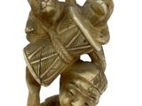 a figurine of a woman holding a fan and a monkey on her head