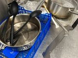 pots and pans sit on a metal counter top in a kitchen
