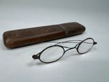 une paire de lunettes et un étui en bois posés sur une table