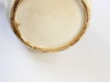 un vase blanc bordé de brun posé sur une table