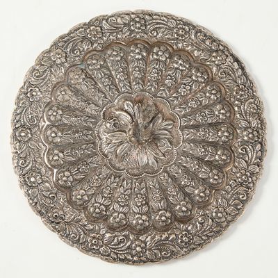 une assiette en argent ornée d'un motif floral