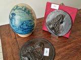 deux vases posés sur une table sur laquelle se trouve une plaque