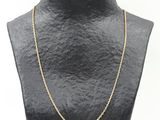 un collier à chaîne en or sur le torse d'un mannequin